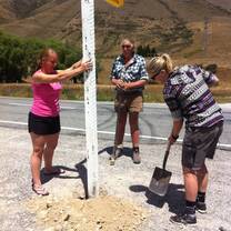 people digging by a sign