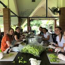 Team members are sitting on a table, preparing food to distribute in the village. 