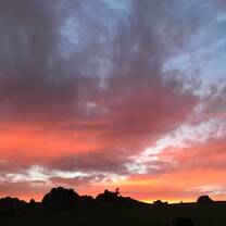 The most beautiful sunset ever seen with a mountain range shadowed over.