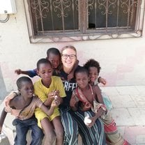 A picture of me and a few kids while they were enjoying the breakfast they got from Projects Abroad.