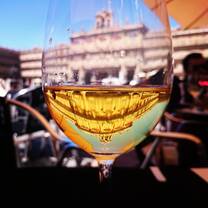 A beautiful view of Plaza Mayor in Salamanca, Spain, reflected through a glass of Spanish wine, capturing the cultural and travel experiences offered by RVF International's Teach English in Spain program.