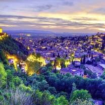  A breathtaking view of Granada, Spain, at sunset with the Alhambra Palace glowing brightly, showcasing the rich history, culture, and beauty explored through RVF International's Teach English in Spain program.