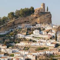 A picturesque Spanish pueblo village with white houses and a historic church perched on a rocky hillside, showcasing the cultural charm and unique travel opportunities offered by RVF International's Teach English in Spain program.