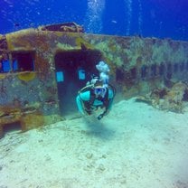 Diver exiting sunken plane wreck.