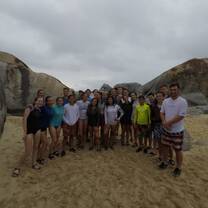 students standing in group on beach 