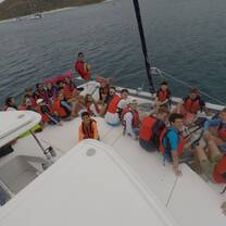 students gathered on front of one of the boats used for program