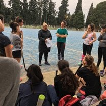 My field hockey team gathers around our coach to discuss a play