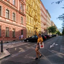 Girl standing in the street, posing in front of colorful buildings.