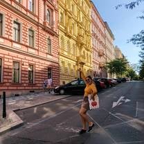 Girl standing in the street, posing in front of colorful buildings.