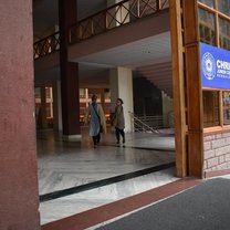 Two USAC students entering the building that our classes were in. Image shows a large, open lobby that allows for the breeze to pass through.