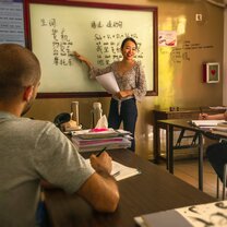 A teacher gestures to the whiteboard, explaining to two students The inside of an Omeida classroom