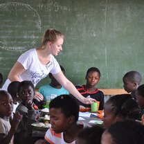 Assisting with serving drinks at feeding Scheme Assisting with serving drinks at feeding Scheme