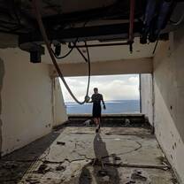 Silhouette of one of the participants created by the sunlight shining in from a huge open window in an abandoned hotel 