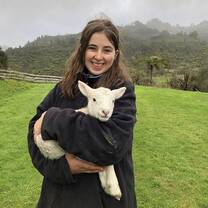 A woman holding a sheep in New Zealand with Yep IS