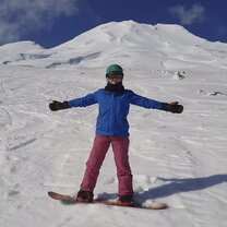 A woman snowboarding on the winter slopes in New Zealand with Yep IS