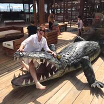 A student has his leg through the large jaws of a statue alligator and is pretending to be scared