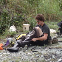 A student pulls up his boots to do field work