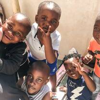 Várias crianças fazendo pose para foto e abrançando a voluntária.