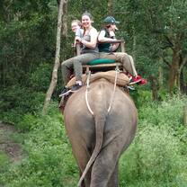 Travelors riding on the back of an elephant.