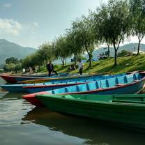 A photo from the water edge, overlooking classic. colorful canoes on the shore.
