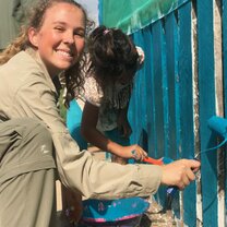 An intern painting a schoolhouse in a nearby native community.