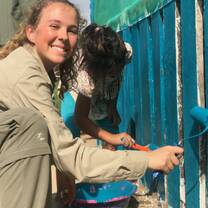 An intern painting a schoolhouse in a nearby native community. 
