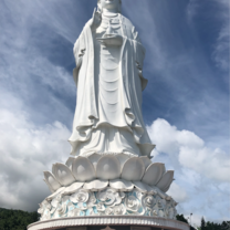 White statue of Lady Buddha standing on a lotus flower, 220 feet tall 