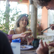 Participant buttering toast during a community dinner.