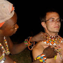 Volunteer being adorned with traditional dress