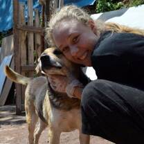 Volunteer hugging a dog