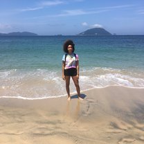 Grace standing in front of the ocean at Shikanoshima facing the camera with the wind blowing