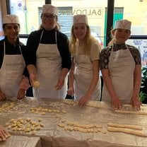 four friends making pasta together