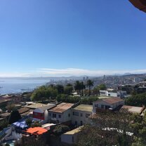 A window view of colorful Valparaiso and the Pacific, with Vina del Mar on the horizon.