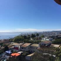 A window view of colorful Valparaiso and the Pacific, with Vina del Mar on the horizon. 