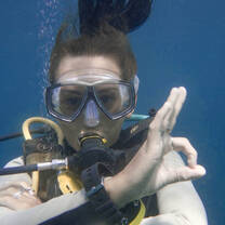 Diver in water doing OK sign 