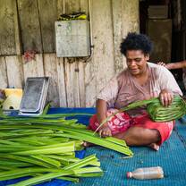 Native women preparing leaves for her mat weaving business