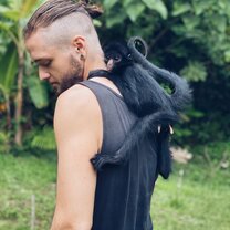 An Hoja Nueva mentor taking a rescued spider monkey outside for the first time.