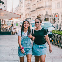 two girls walking down the street together
