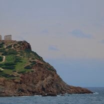 Cape Sounion is the Temple of Poseidon. It is an ancient ruin with tall columns. It lies on top of a large cliff right on the water.