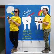 Volunteers painting educational mural in Peru