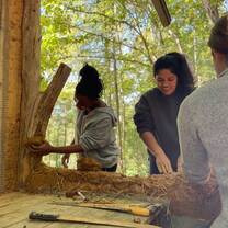 girls working with cob at natural building school
