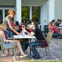 Participants sitting around tables on the terrace and talking