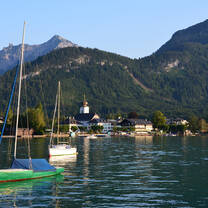 View of boats on lake Wolfgang with the village Strobl and mountains in the background