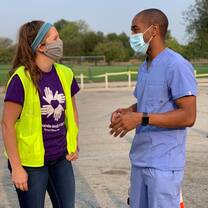 A volunteer talks with a local physician