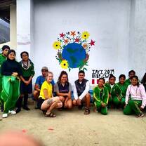 IAYI cohort poses in front of mural