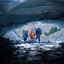Students framed by a clear blue glacier