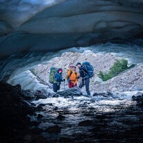 Students framed by a clear blue glacier