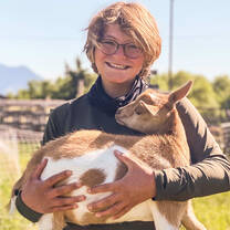 Summer ranch participant holds a goat.