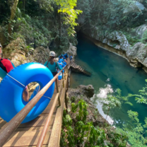 Students descend a stairway to tube through a cave system.