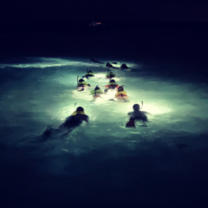 Students snorkel off of Tobacco Caye at night. 